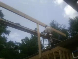 Carpenter setting a ridge beam over a new addition frame — Ice Dam Removal by Roofing Brothers in Red Lake Falls