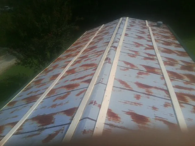 Rusted metal roof panels with new wood purlins before replacement — Storm Damage Roof Repair in Red Lake Falls by Roofing Brothers