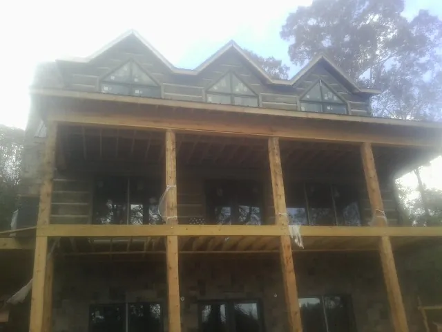 Dormers and porch framing on a large log home under construction — Roof Coating work by our crew in Red Lake Falls
