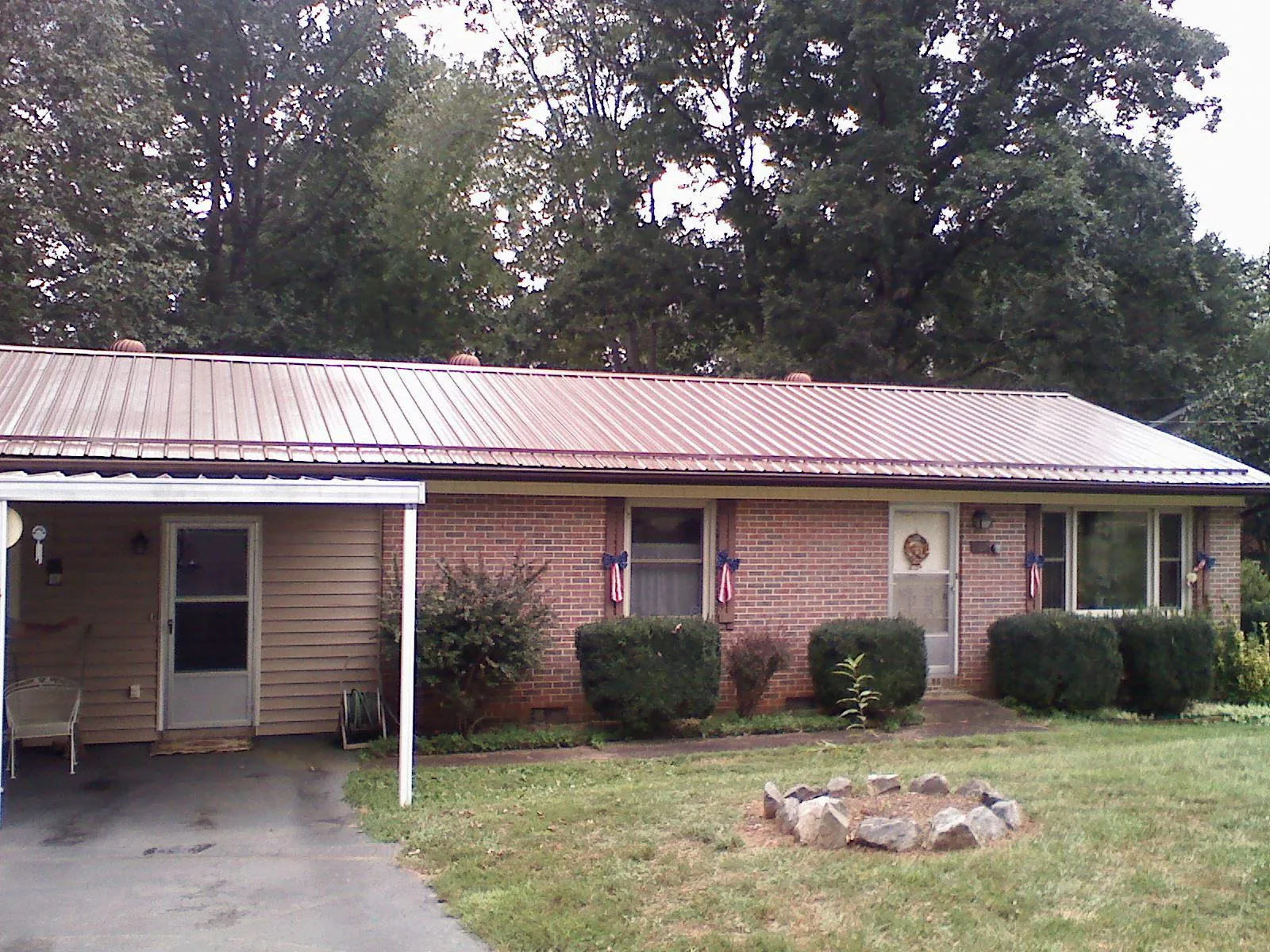 Bronze metal roof and carport on a brick ranch home — Roof Repair work by our crew in Red Lake Falls